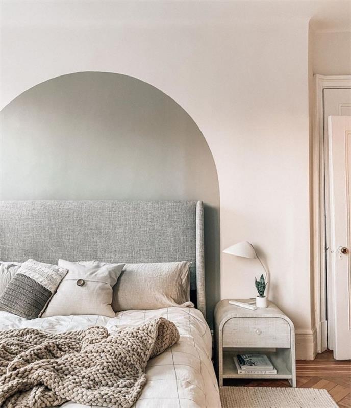 Minimalistično vzglavje za steno v spalnici v sivi barvi, okrašeno z mrežastimi okrasnimi blazinami