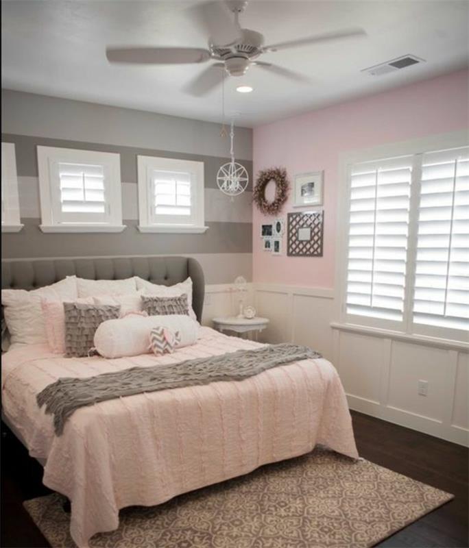 prašno roza stena in siva stena s sivimi črtami, siva postelja, sivo in roza posteljnina, orientalska preproga, barva spalnice za odrasle