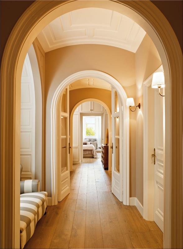 ideja pobarvati hodnik z veliko vrati in arhitekturnimi elementi, hodnik z oker barvo sten z belimi vrati in lesenimi izdelki