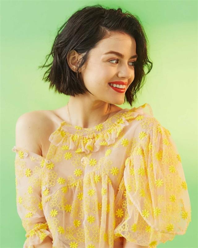 kratki kodrasti lasje, model gole bluze z rumenimi cvetovi in ​​spuščenim rokavom, pričeska zvezdnice Lucy Hale