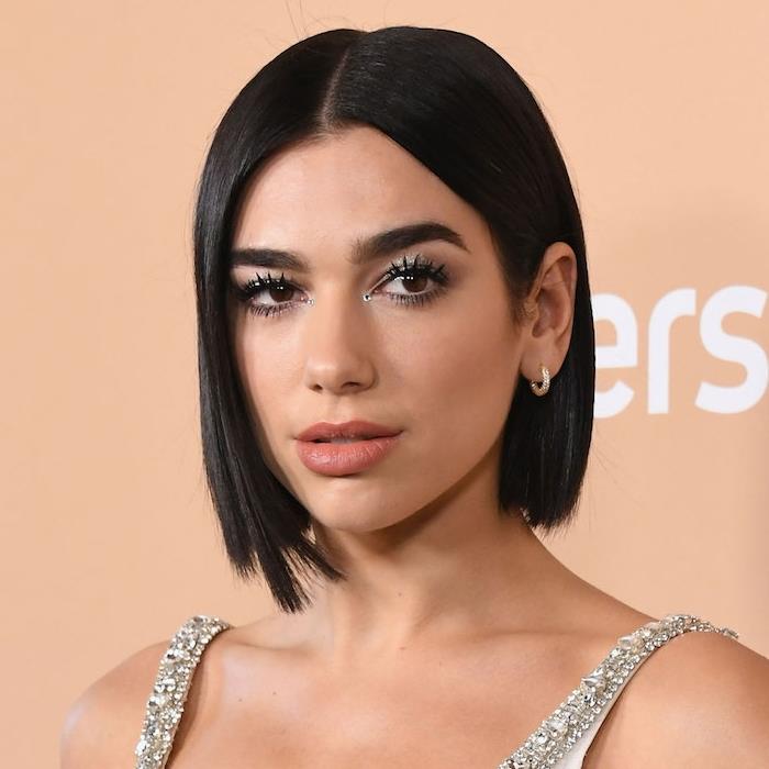 dua lipa'nın kısa dalgalı bob modeli, kısa saç kesimi koyu kahverengi saç, ortadan ayırma ve düz saç