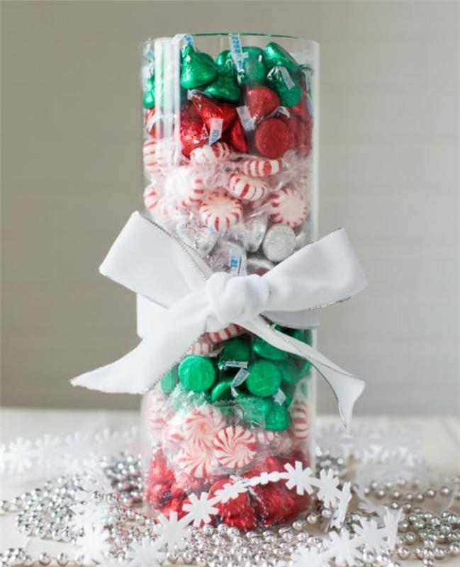 cilindrični rezalnik stekla, napolnjen s sladkarijami in okrašen s fantastično božično mizo, okrasnim trakom