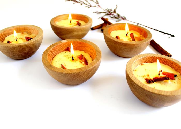 kako narediti sveče, voščene sveče v majhnih lesenih skodelicah s cimetovimi palicami v notranjosti