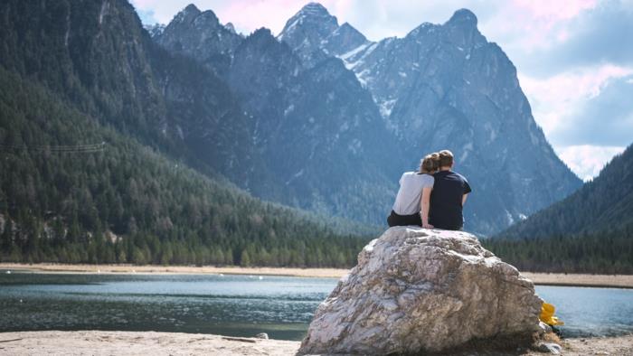 Kanada dağındaki güzel bir gölün kenarında bir kayanın üzerinde oturmak, Sevgililer Günü resmi, sevgilinize gönderebileceğiniz Sevgililer Günü kutlu olsun