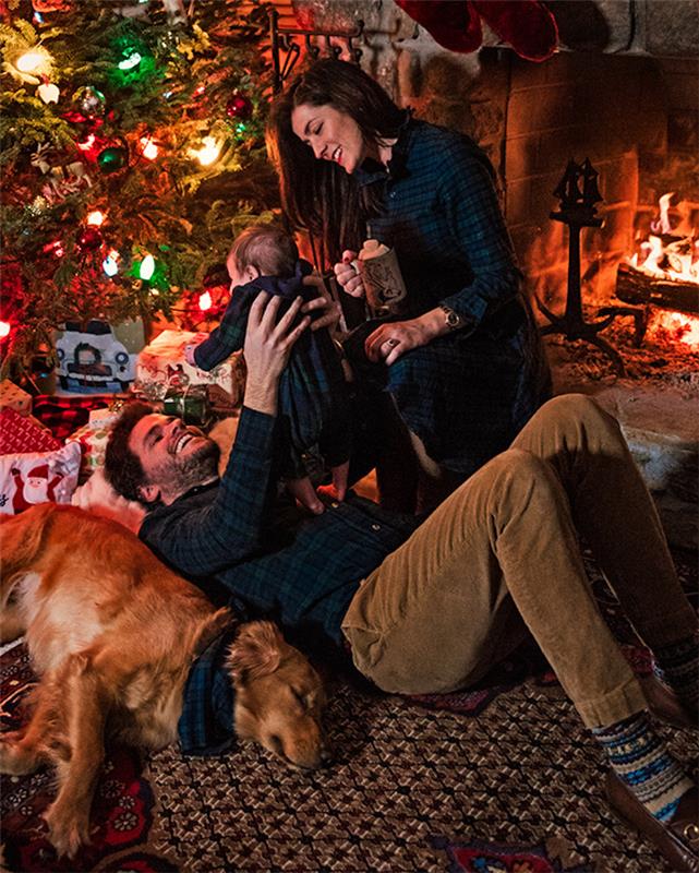 Božično drevo okrasi, skupaj z otrokom in njihovim psom, praznuje božič v prijetni brunarici