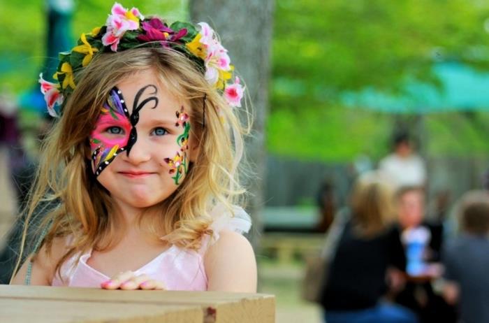 slikajte na otrokovem obrazu, da ustvarite izvirno masko kostuma, deklico z metuljčkom, ki riše na obrazu
