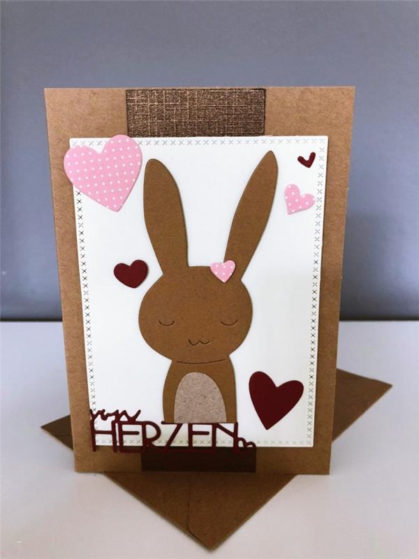 küçük tavşanlar ve küçük pembe renkli kağıt kalplerin şirin tasarımı ile kahverengi karton kart