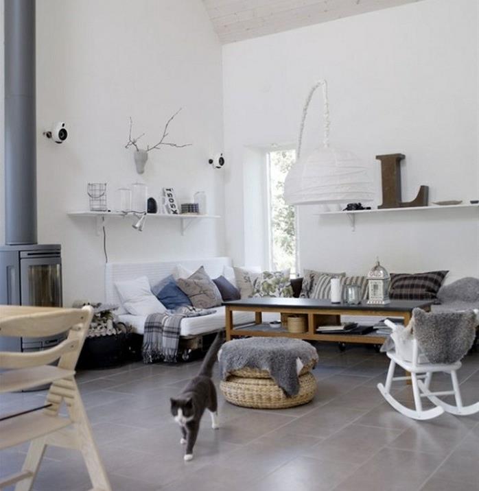 koza şeklinde oturma odası dekoru, sallanan sandalye, beyaz kanepe, dekoratif minderler, gri şömine, beyaz duvarlar