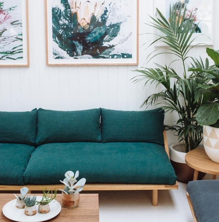 idėja apie mėlyną benzininę sofą, traukiančią prie žalios, medinį kavos staliuką, žalius augalus, baltas dailylentes ir sienų apdailą tapybos paveikslai natūralus raštas