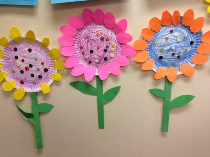 obrtne ideje za otroke, tri rože iz papirnatih plošč, obarvanih s svinčniki, s peclji iz zelenega papirja in cvetnimi listi iz rumenega, roza in oranžnega papirja