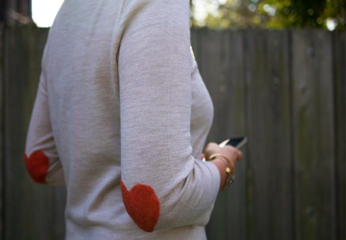figūros menas ant vilnonio megztinio, baltas megztinis, oranžinės širdelės rankovėms