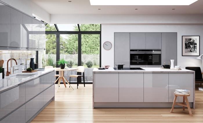 Beyaz ve gri lake mobilyalarla donatılmış ahşap zeminli beyaz bir mutfakta çağdaş tasarım