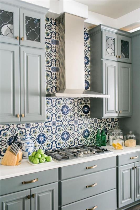 kuhinja iz cementnih ploščic, vzorec ploščic s cvetličnim dizajnom in zeleno in modro barvo, sivo pobarvano leseno pohištvo