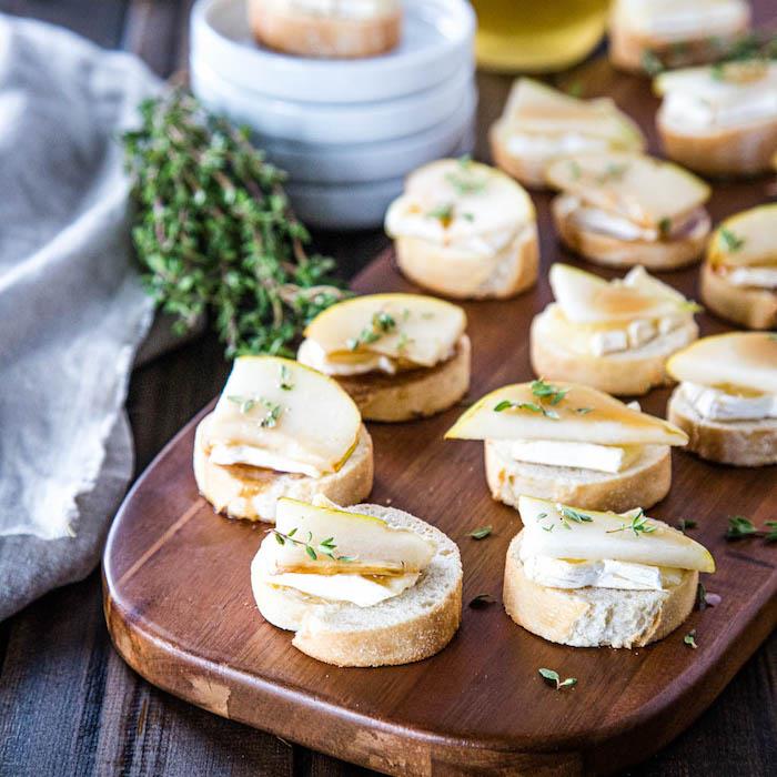 rezine baguette z rezino sira na vrhu in hruško ter svežim timijanom, božično -novoletni apero toast