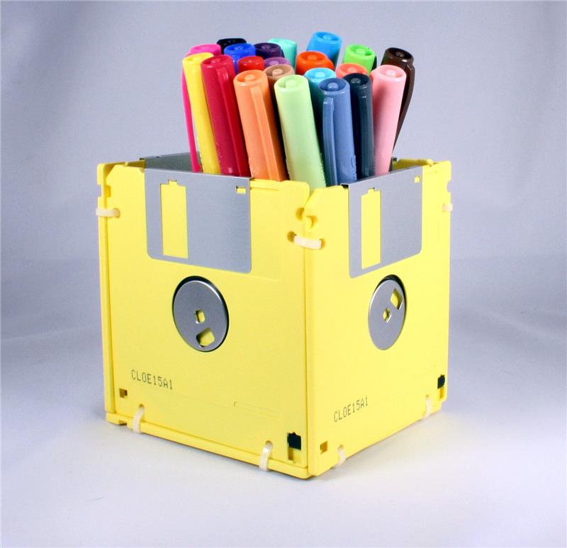 İçinde farklı renklerde birkaç sarı disketten, sanat ve zanaat fikirlerinden, keçeli kalemlerden veya kalemlerden yapılmış bir kalem kutusunun yakın çekimi
