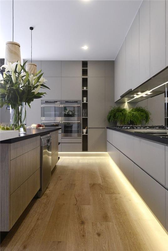 tavana kadar kulpsuz mobilyalarıyla temiz çizgilere sahip mat açık gri bir mutfağın modern tasarımı