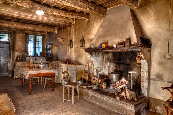 kmečka kuhinja, betonski kamin, lonec, karirano okno, strop z lesenimi tramovi