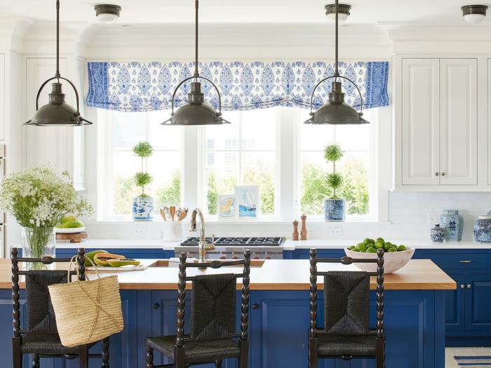 mėlyna ir balta virtuvė, juodos kabančios lempos, virtuvės sala su mediniu skaitikliu, mėlyni baldai