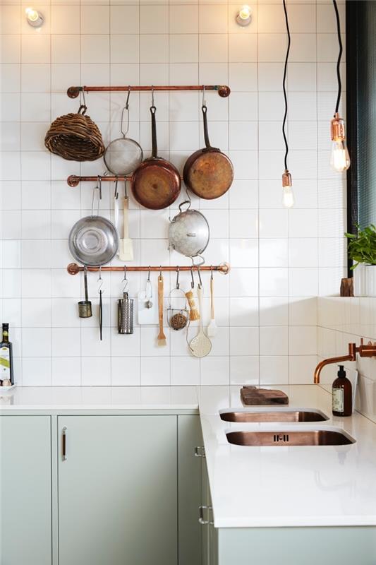 işlevsel bir bistro tarzı mutfak düzenlemek için deko ucu, bakır desenli beyaz ve badem yeşili eski İskandinav mutfağı, duvara bağlı bakır borulu mutfak eşyası tutucuları