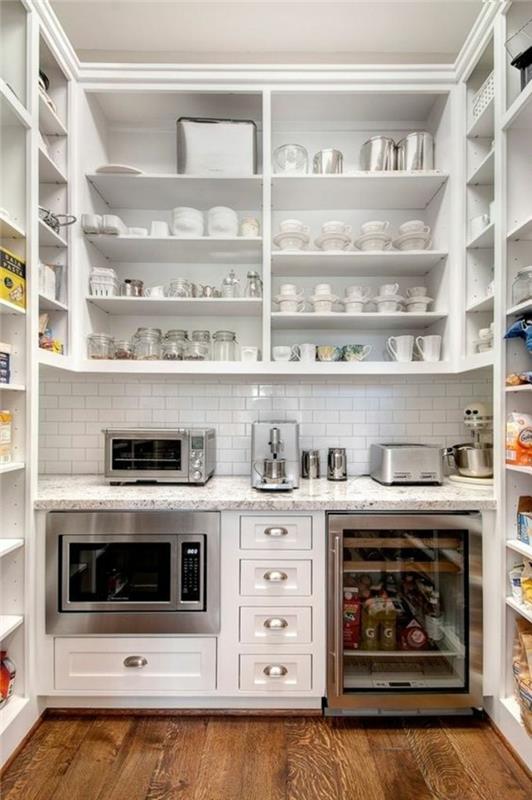 model kuhinje ikea, bele police z gospodinjskimi pripomočki, rjavi parket, peči, majhen hladilnik s stekleno vitrino, bela opeka