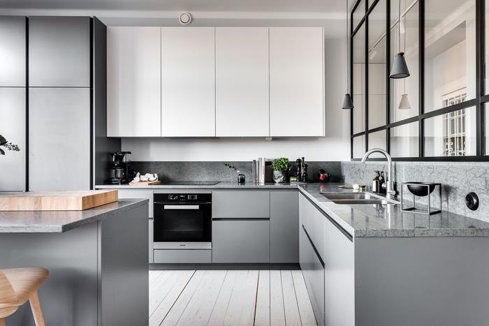 birkaç siyah vurgu sayesinde sadeliği ve zarafeti birleştiren minimalist temiz tasarıma sahip beyaz ve gri bir mutfak