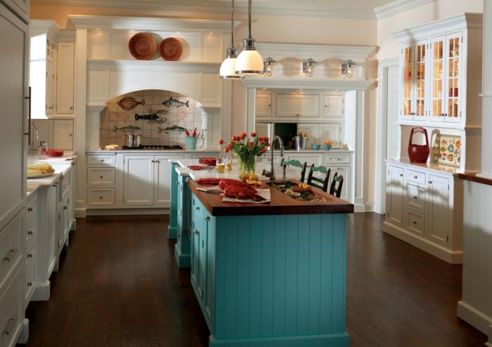 balta ir medinė virtuvė, medinės grindys, smėlio spalvos lempos, balti virtuvės baldai, senos kėdės