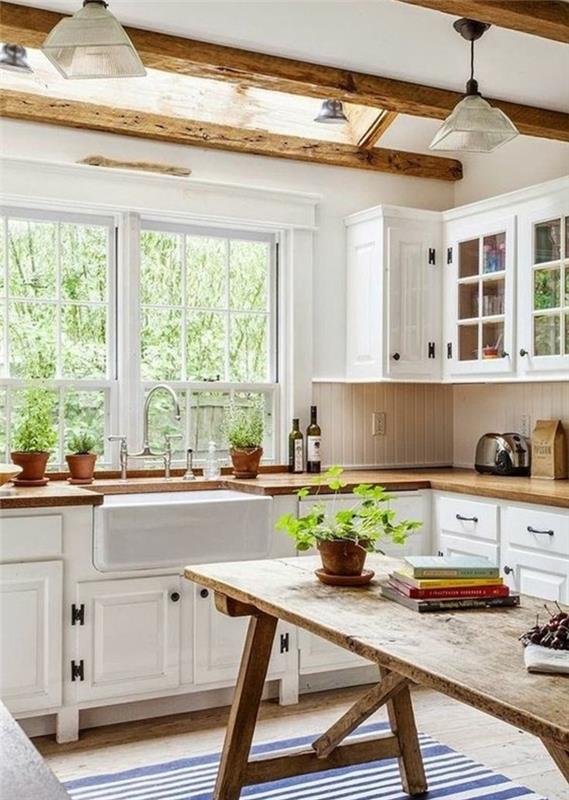 primer elegantne podeželske kuhinje, miza iz surovega lesa, bela kuhinjska fasada, belo -modra črtasta preproga, izpostavljeni tramovi, lesena delovna plošča, rastlina