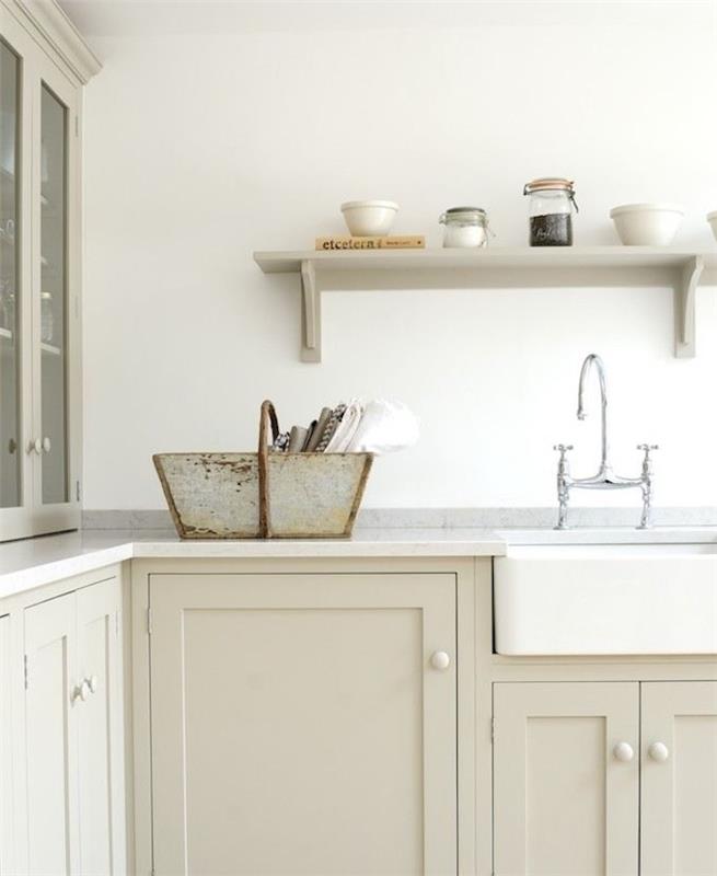 svetla taupe kuhinjska sprednja stran z belo delovno ploščo in biserno sivo polico, sivimi pipami, belim umivalnikom, kovinsko košaro za shranjevanje posode