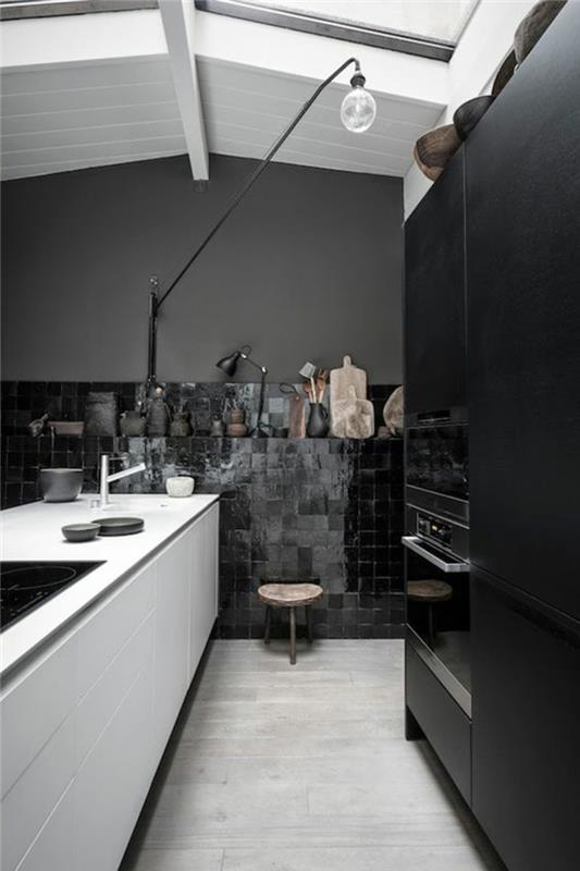 bir duvarda beyaz kirişler ve koyu siyah mozaik ile eğimli bir çatı altında siyah mutfak