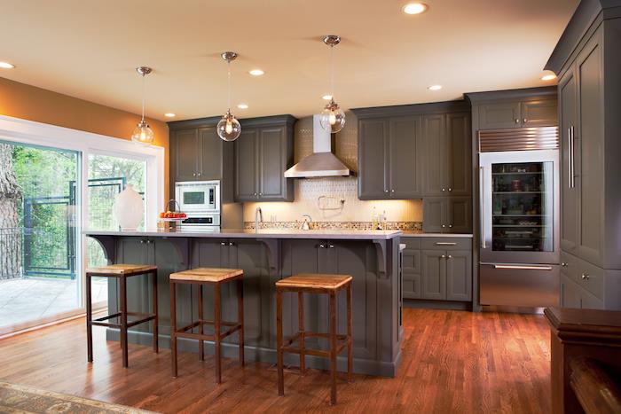 didelė virtuvė, nudažyta pilka spalva, atvira iki tamsios medinės parketo grindys