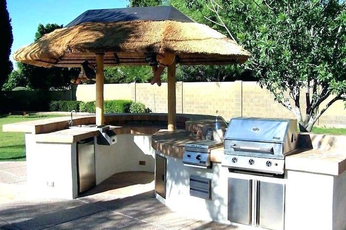 ahşap bir çatı ve gazlı ızgara ve s şeklinde tezgah ile kaplı yaz mutfağının fotoğrafı