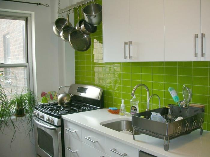 bela lakirana kuhinja, moderno opremljena kuhinja, svetlo zelena stena s ploščicami, belo pohištvo in štedilniki iz nerjavečega jekla