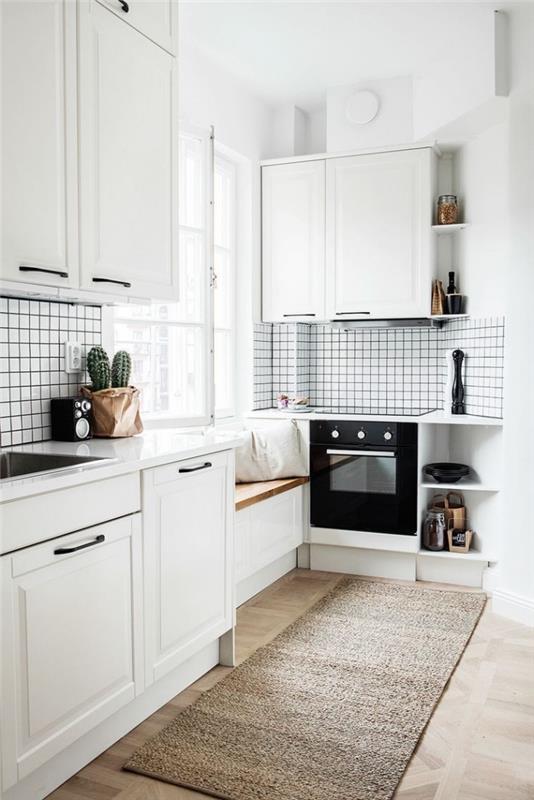 Skandinavski dekor, lesena in bela klop z belimi pokrovi pod oknom, črna pečica v beli kuhinji