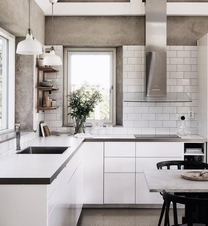 pilka ir balta virtuvė su betono sienos imitacija, balta virtuvės spintelė ir pilkas stalviršis, pilkas dulkių siurblys ir stiklas, maža kampinė lentyna