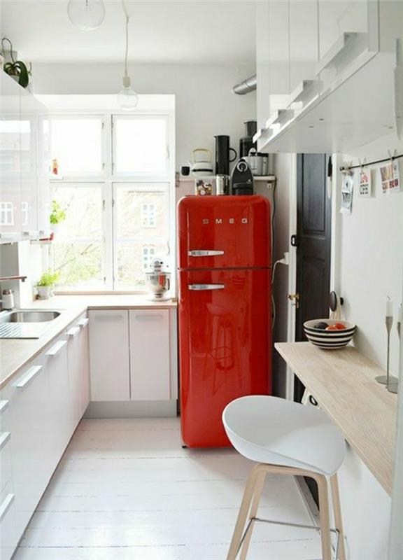 ikea mutfak modeli, vintage tarzda alev kırmızısı buzdolabı, imitasyon hafif ahşap tezgah, yemek masası olarak kullanılmak üzere duvara yapıştırılmış imitasyon ahşap yüzey, beyaz plastik sandalye ve hafif ahşap ayaklar
