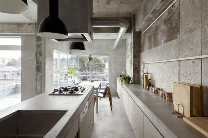 beton tezgah ve tezgah ile boylamasına yerleştirilmiş ham görünümlü endüstriyel mutfak