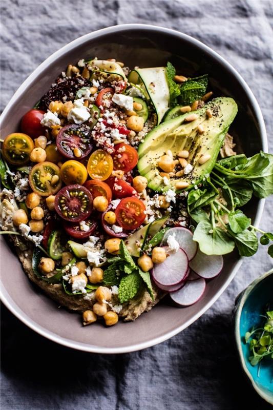 Šviežios vitaminų supakuotos graikų salotos su quinoa, avinžirniais, vyšniniais pomidorais, avokadu, ridikėliais ir ožkos sūriu bei naminiu humusu