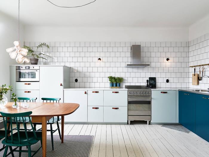 Skandinaviško stiliaus balta virtuvė su spalvingais povo mėlynos ir ančių žalios spalvos akcentais