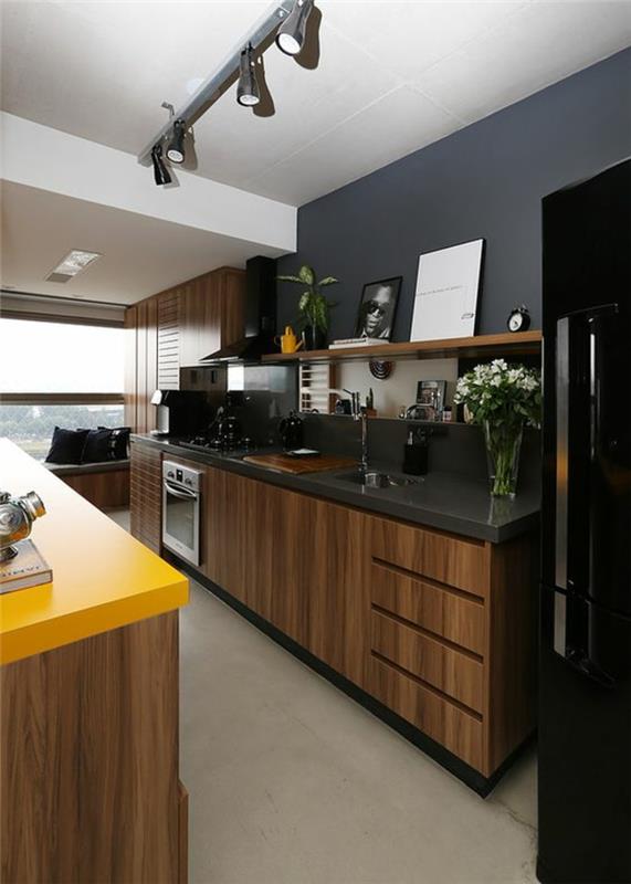 metal bir çizgi üzerinde siyah ve sarı tezgahlı tavan aplikleri ile siyah mutfak dekoru