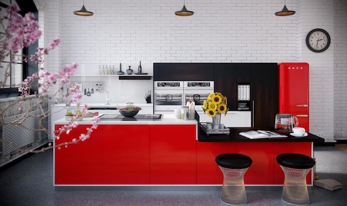 rdeče -črni dekor, hladilnik in rdeči osrednji otok, črno -bela delovna plošča, siva tla, rjava lesena kuhinjska omara, bela opečna stena, industrijske viseče luči