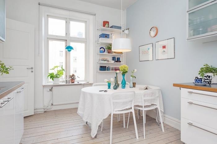 Skandinavski dizajn, laminatna lesena tla z belimi stenami, svetlo modre steklene kuhinjske omare
