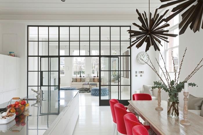 napol odprta kuhinja, beli dekor sobe s sodobnim pohištvom in beli strop z ločevalno stekleno streho
