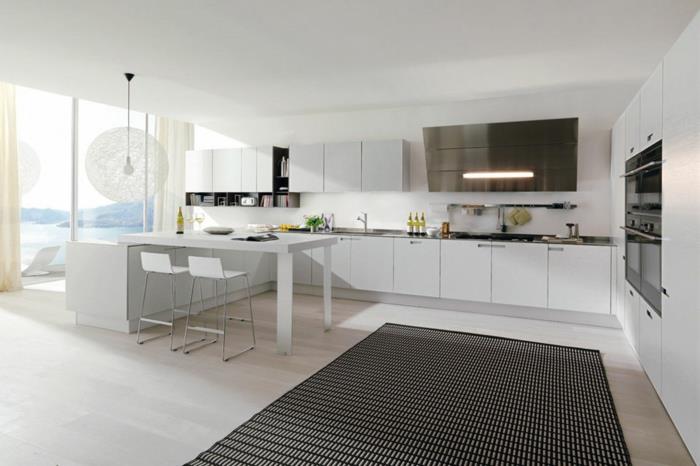 baltos virtuvės, iš kurių atsiveria puikus vaizdas į vandenyną, juodas kilimas, šviesios parketo grindys