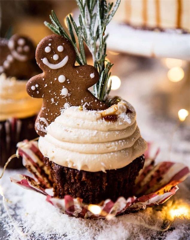 çırpılmış krema tepesi ve kakao ve Noel çivileri, biberiye dekorasyonu ve zencefilli kurabiye adam kurabiyesi ile zencefilli kek hazırlığı