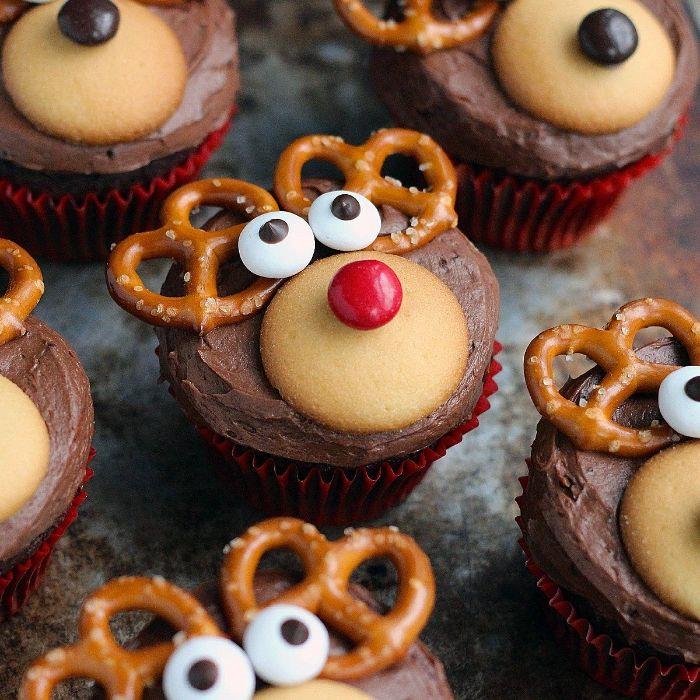 božični kolač rudolphe, okrašen s čokoladno kremno piškotko, pisane sladkarije in ušesa iz pereca