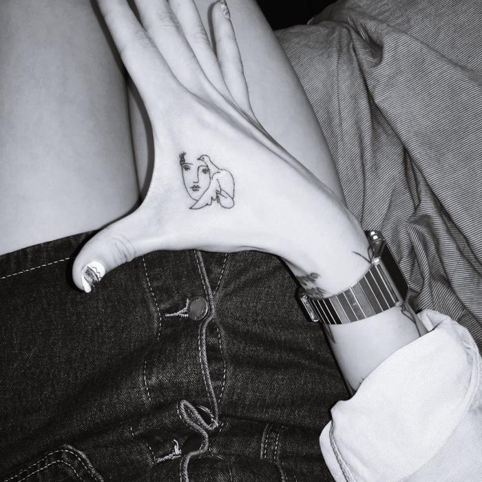 luštne tetovaže za dekleta, ženski obraz in ptica, ročna tetovaža, črno -bela fotografija, krilo iz jeansa