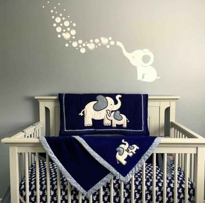 kūdikio kambario dekoras mėlynos ir pilkos spalvos, antklodė su baltais drambliais, šviesiai pilki sienų dažai