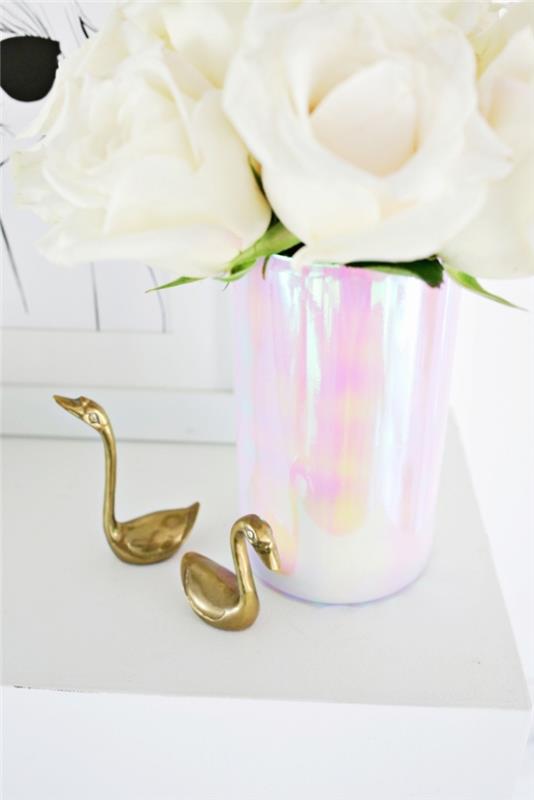 kūrybingas gimtadienio stalo dekoravimas, baltos rožės, dekoratyvios auksinės gulbės, vaza, papuošta holografiniu popieriumi