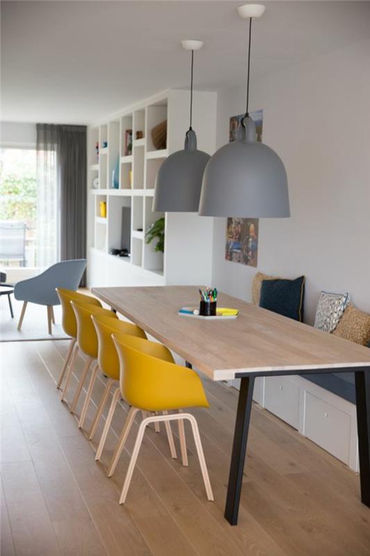 oturma odasına açılan İskandinav tarzı bir yemek odası, doğal ahşap aksanlarla ilişkili gri ve sarı dekor