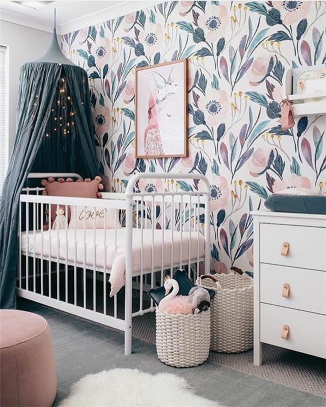 kūdikio kambario rėmas, rožinis ir pilkas kambarys, pastelinės mėlynos spalvos baldai, siena su didelėmis ančių mėlynos ir rožinės spalvos gėlėmis, tinklelis nuo uodų benzino mėlynos spalvos, apvali išmatos rausvos spalvos